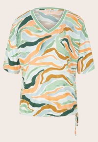 Blouse à manches courtes avec col en V, rayures ondulées abstraites en vert, orange, marron et bleu clair, avec un lien latéral à l'ourlet.