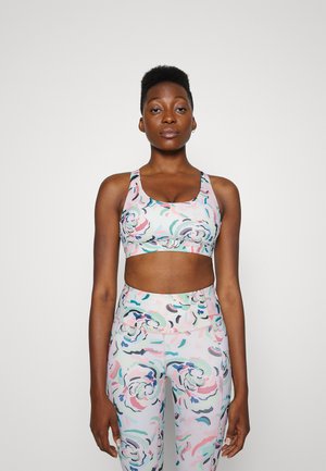 Conjunto de roupa desportiva com padrão floral em cores pastel. O sutiã desportivo possui uma banda larga e decote arredondado, complementado por leggings de cintura alta.