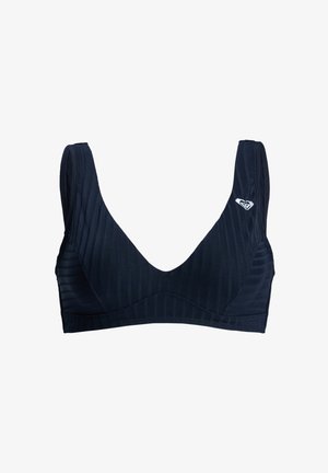 Brassière de sport noire côtelée avec larges bretelles et petit logo blanc sur le côté supérieur gauche, conçue pour les activités physiques.