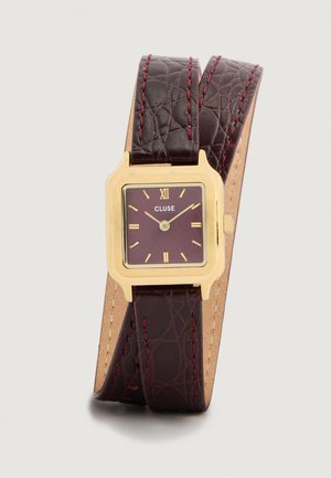Orologio quadrato color oro con cinturino in pelle testurizzata bordeaux. Il quadrante presenta numeri romani, indicatori delle ore dorati e un design minimalista.