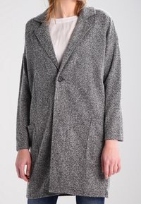 Šedý kabát ve vzoru herringbone s uvolněným střihem, zapínáním na jeden knoflík a dvěma bočními kapsami, vyrobený z texturované tkaniny.
