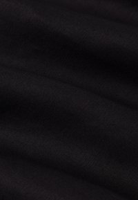 Czarny materiał o gładkiej teksturze i subtelnym połysku, prezentujący delikatny splot i lekki spływ. Bez widocznych wzorów czy detali na powierzchni.