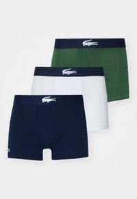 Three-pack of boxer briefs in navy blue, white, and green. Features soft cotton material, elastic waistband with logo, and fitted design.