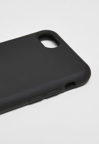 Crna maska za telefon s mat finišom, s izrezima za objektiv kamere i priključak za punjenje, zajedno s teksturiranim akcentima tipki.