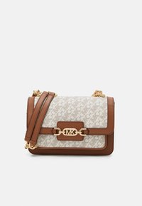 Borsa crossbody in tela monogram beige. Accenti in pelle marrone, hardware dorato, tracolla a catena e dettaglio della chiusura frontale.