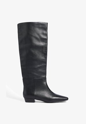 Knöchelhohe schwarze Lederstiefel mit spitzer Zehenform und niedrigem Blockabsatz. Glatte Textur mit subtilen Falten und einer abgerundeten oberen Öffnung.