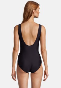 Zwarte badpak met een lage rug, brede bandjes en een gladde textuur. Heeft een strakke pasvorm en minimale stikdetails.