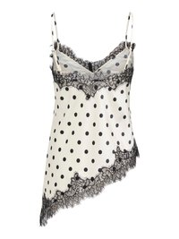 Camisole en satin blanc à pois noirs, bordure en dentelle noire le long de l'encolure et ourlet asymétrique, avec fines bretelles réglables.