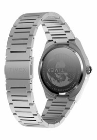 Montre en acier inoxydable avec un bracelet en métal argenté, un boîtier octogonal et un cadran rond noir arborant un design de globe au dos.