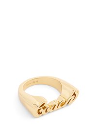 Anillo de metal en tono dorado con el logo "Coach" recortado y una pequeña piedra de acento, diseño elegante con una textura suave y pulida.