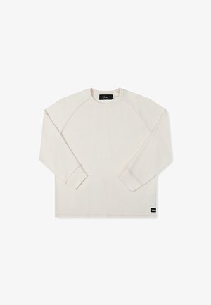 Pikkade varrukatega kreemjas sweatshirt, millel on soonikkoes, raglanvarrukad ja diskreetne brändi silt allääres. Sile kangas, millel on minimaalsed õmblused.