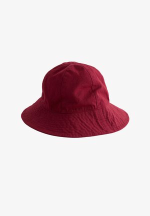 Chapeau seau en coton rouge avec bord large et incliné vers le bas, design à panneaux cousus, présenté sur fond blanc.