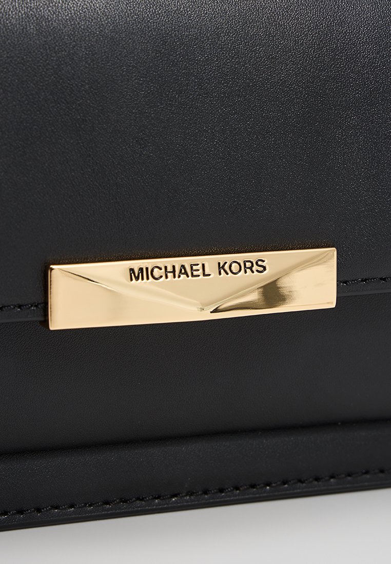 Czarny skórzany portfel o gładkiej fakturze, z złotą metalową tabliczką z napisem "MICHAEL KORS" oraz subtelnymi akcentami w postaci stebnowania.
