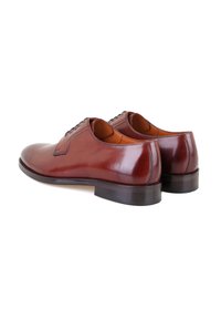 Chaussures habillées en cuir marron avec une finition brillante, bout rond et lacets, dotées d'une semelle noire robuste et d'accents cousus.