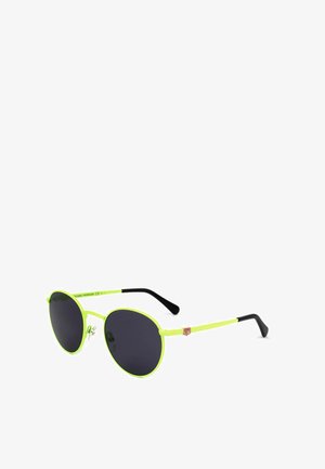 Occhiali da sole rotondi con montatura giallo neon, lenti scure, terminali delle aste neri e piccolo logo rosso sul lato.