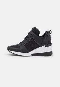 Czarne sportowe sneakersy z teksturowaną siateczką, gładkimi skórzanymi akcentami, białą podeszwą oraz grubym podniesieniem, które zwiększa wysokość.