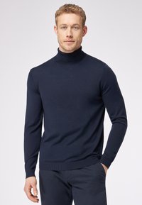 Navyblauer Rollkragenpullover aus feinem Strickmaterial, mit langen Ärmeln und gerippten Bündchen, in taillierter Passform und mit dezenter Textur.