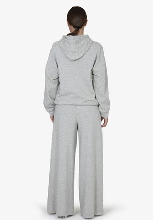 Lichtgrijze hoodie en wijde broek set gemaakt van zachte, textuurstof. Heeft een capuchon en een relaxte pasvorm met zichtbare stikseldetails.