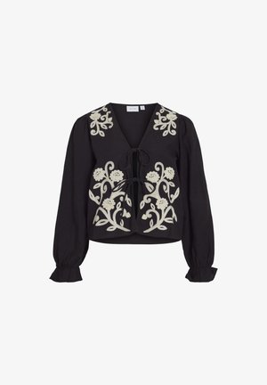 Sort bluse med V-udskæring og lange pufærmer, prydet med hvid blomsterbroderi og en snøre lukning foran. Flæsemanchetter.