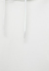 Close-up van witte hoodie-stof met twee hangende koorden met plastic aglets aan de uiteinden.