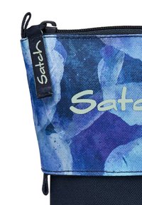 Pochette en tissu bleu et violet à motifs avec une base noire, présentant un logo "Satch" gris bien en vue et une fermeture éclair noire.