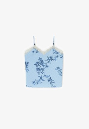 Lyseblå camisole med tynde stropper, diagonale hvide striber, blå floral print og hvid blondekant langs halsudskæringen.