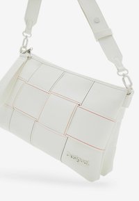 White crossbody bag with a woven design, featuring rectangular panels stitched with red and black accents. Brand name "Desigual" embossed.
