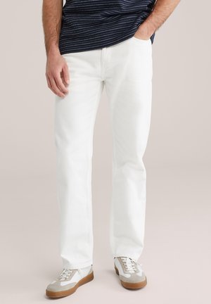 Witte spijkerbroek met een rechte pasvorm, gemaakt van denim, met vijf zakken en minimale stiksels, gecombineerd met grijze en witte sneakers.