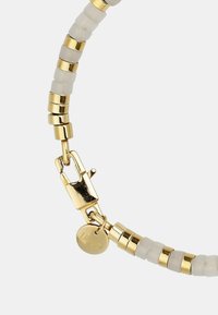 Bracciale placcato in oro con perle alternate opache bianche e lucide dorate, dotato di un fermaglio sicuro e di un piccolo marchio.