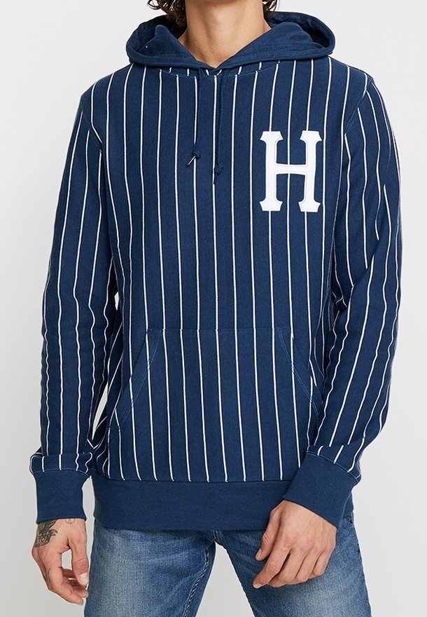 Mörkblå randig hoodie med vita vertikala ränder, framficka och en stor vit "H"-logotyp på bröstet. Bomullsblandad tyg.