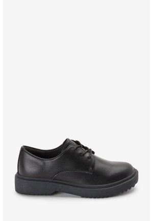 Chaussure noire en cuir à talon bas avec lacets, finition texturée et semelle épaisse en caoutchouc, vue de côté sur fond blanc uni.