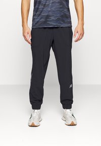 Black jogger pants made of lightweight fabric, featuring elastic cuffs and two side pockets. Includes a small logo detail on the thigh.