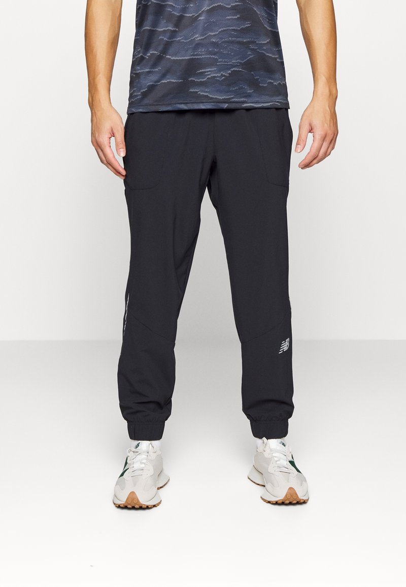 Black jogger pants made of lightweight fabric, featuring elastic cuffs and two side pockets. Includes a small logo detail on the thigh.