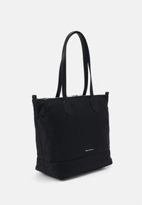 Svart rektangulär tote väska med dubbel lång handtag, toppdragkedjestängning och liten logotext längst ner i mitten på framsidan.