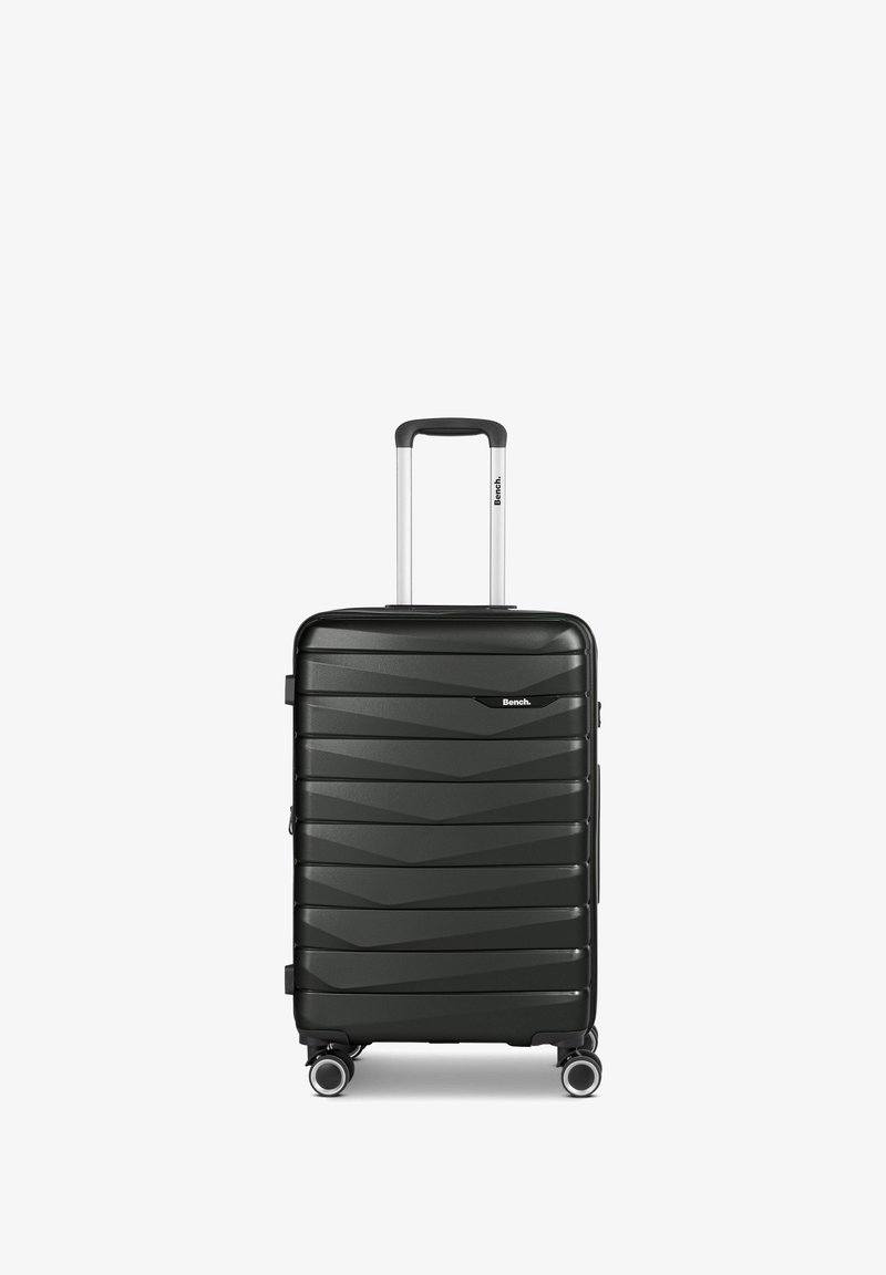 Valigia rigida nera con un motivo a zigzag testurizzato, manico retrattile e quattro ruote girevoli per una facile mobilità.