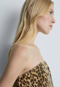 Top senza spalline con stampa leopardata in morbido tessuto, caratterizzato da tonalità di marrone e beige, con una forma aderente che mette in risalto le spalle.
