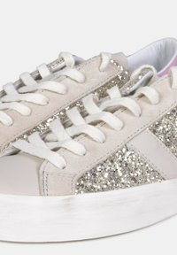 Beige ruskind sneakers med glimmerdetaljer, hvid gummisål og matchende snørebånd. Rund tå og minimalistisk design.