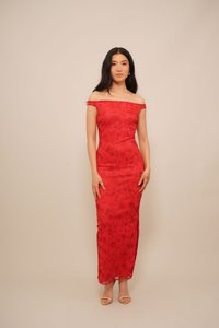 Rochie roșie cu umeri descoperiți, cu un model floral, croi ajustat și suprapunere transparentă; asortată cu sandale deschise la vârf, ușoare.