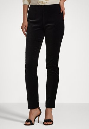 Pantaloni neri slim-fit realizzati con un tessuto elegante; presentano una texture liscia e si posizionano in vita. Abbinate a scarpe col tacco nere.