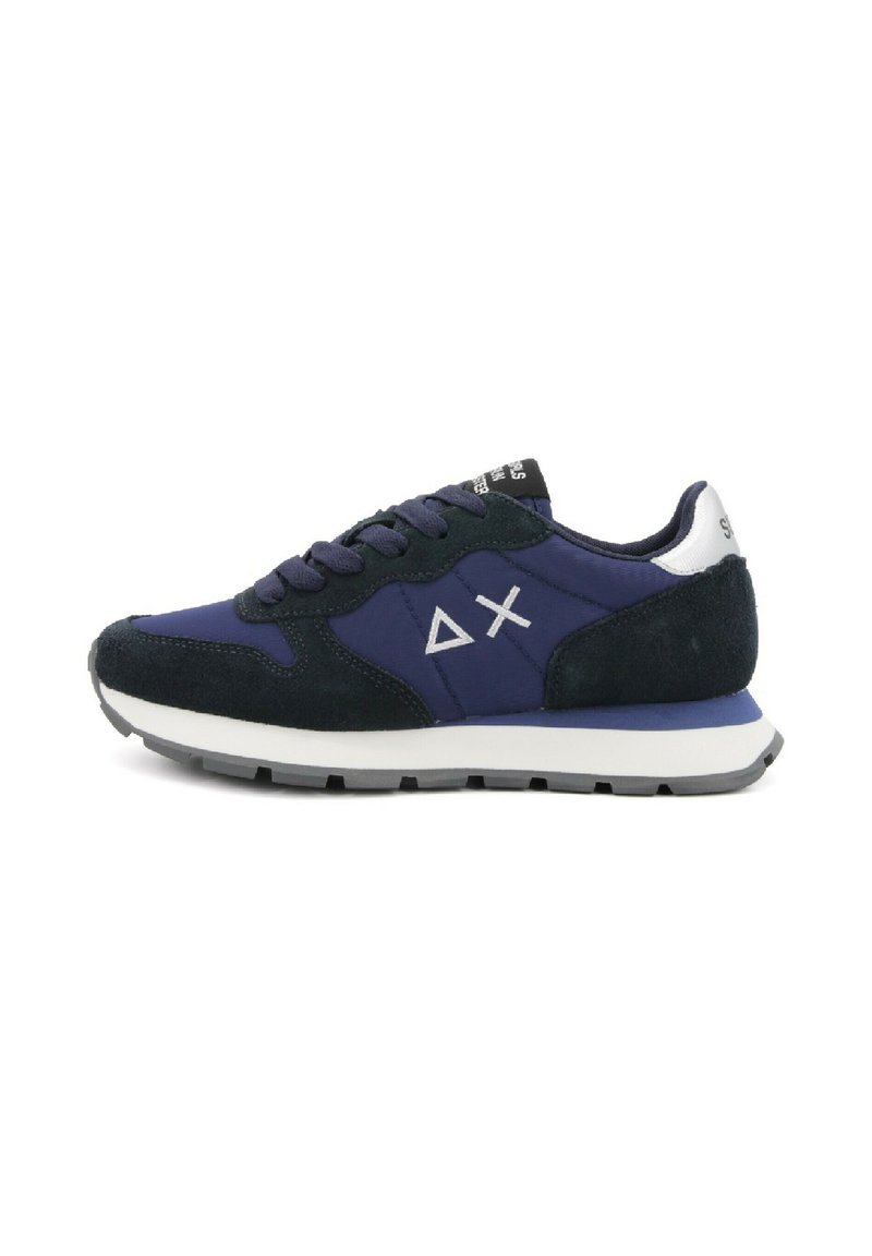 Marineblauw en zwarte sneaker met een witte zool, suède accenten, veters en een wit driehoek- en X-logo aan de zijkant.