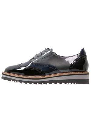 Czarne i ciemnoszare lakierowane buty oxfordy z detalami typu wingtip, grubą, warstwową podeszwą oraz wiązaniem na sznurowadła.