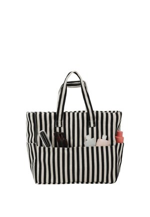 Schwarz-weiß gestreifte Tragetasche mit Vorderfächern, die eine Haarbürste, eine Haarklammer und Kosmetikflaschen enthalten.