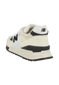 White sneaker with a textured leather upper, black accents, prominent 'N' logo, and a cushioned sole featuring an ABZORB® logo.