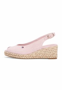 Sandale compensée rose clair à bride arrière, bout ouvert, semelle plateforme en jute tressé, boucle réglable, et petit logo brodé sur le côté.