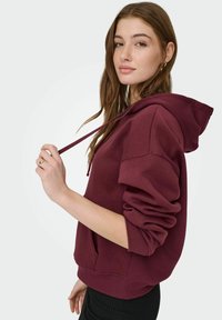 Wijnrode hoodie met trekkoorden, een losse pasvorm en geribde manchetten. Gladde stof met een buidelzak, ideaal voor casual dragen.