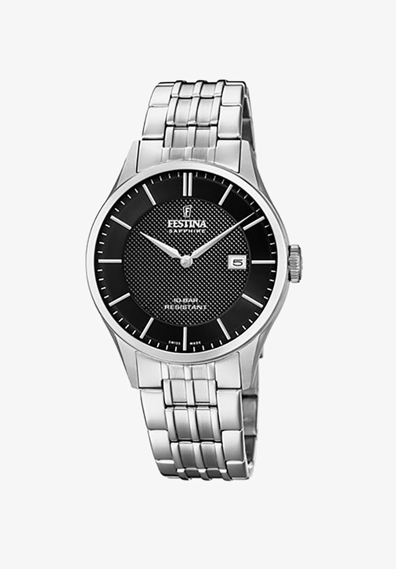 Zegarek na rękę ze stali nierdzewnej z czarną teksturowaną tarczą, srebrnymi znacznikami godzinowymi i wyświetlaczem daty. Posiada bransoletę z metalowych ogniw i szkiełko szafirowe.