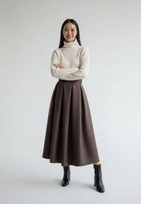 Beżowy sweter z golfem zestawiony z brązową spódnicą w kształcie litery A, ozdobioną zakładkami i paskiem w talii. Noszony z czarnymi botkami na obcasie.