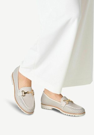 Mocassins perforés gris clair avec des éléments décoratifs en or et des semelles contrastantes, présentant une finition en cuir lisse et un design à bout arrondi.