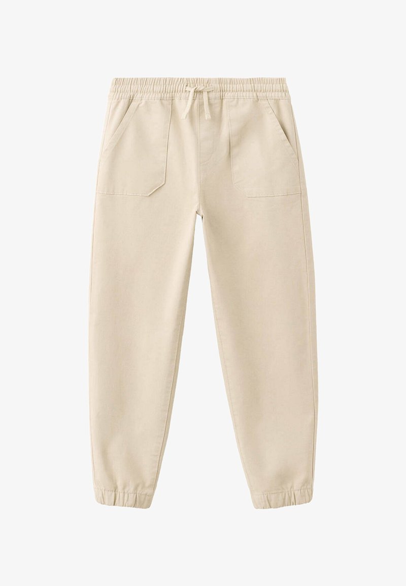 Pantalon jogger beige avec taille élastique, cordon, poches avant et poignets élastiques, présenté sur fond blanc.