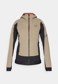Beige en zwarte technische jas met een capuchon, ritssluiting, voorklep en contrasterende oranje voering. Beschikt over elastische manchetten en ademende panelen.